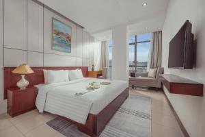 a hotel room with a large bed and a chair at Star Hotel and Spa Danang in Danang