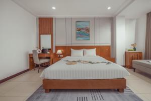 a bedroom with a bed and a desk and a chair at Star Hotel and Spa Danang in Danang