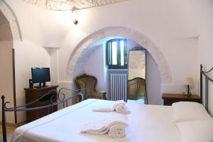 sypialnia z łóżkiem z białą narzutą i lustrem w obiekcie B&B Masseria Piccola w mieście Cisternino +37 zdjęć