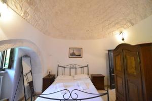 sypialnia z łóżkiem i dużym sufitem w obiekcie B&B Masseria Piccola w mieście Cisternino