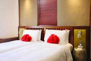 two red stuffed animals are sitting on two beds at Butterfly on Wellington, Central in Hong Kong