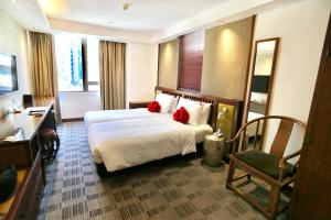a hotel room with a bed and a chair at Butterfly on Wellington, Central in Hong Kong