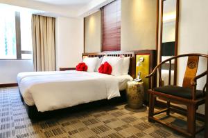 a bedroom with a bed with red pillows and a chair at Butterfly on Wellington, Central in Hong Kong
