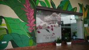 a mural on the side of a building with plants at Flora Airport Hotel and Convention Centre Kochi in Nedumbassery