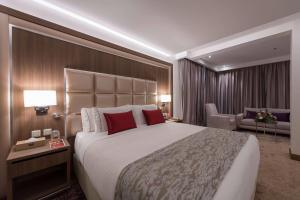 a hotel room with a large bed with red pillows at Ramada by Wyndham Continental Jeddah in Jeddah