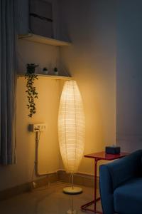 a lamp in a living room with a blue couch at Quirky 1BHK Bandra W by The Bombay Home Company in Mumbai