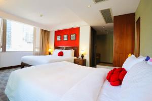 a hotel room with two beds and a red wall at Butterfly on Wellington, Central in Hong Kong