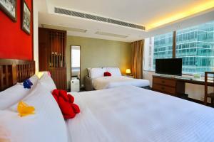 a hotel room with two beds and a flat screen tv at Butterfly on Wellington, Central in Hong Kong