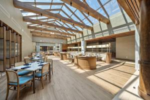 a restaurant with tables and chairs and a large glass ceiling at Hilton College Station & Conference Center in College Station