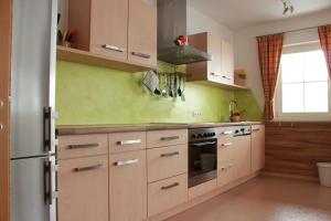 a kitchen with wooden cabinets and a stove at Traum-Ferienwohnungen Wechselberger Schwendau in Schwendau