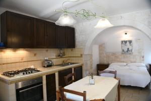 kuchnia ze stołem i łóżko w pokoju w obiekcie B&B Masseria Piccola w mieście Cisternino