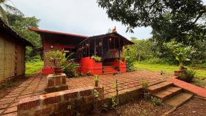 a small house with a brick patio in front of it at Surangi Homestays in Ajgaon