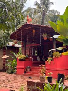 a red house with potted plants on top of it at Surangi Homestays in Ajgaon +12 photos