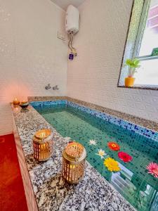 a swimming pool with three buckets in a room at Surangi Homestays in Ajgaon