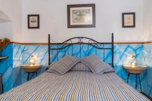 una camera da letto con un letto blu con due comodini di Fuente Nueva a Cazalla de la Sierra