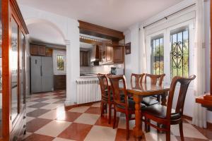 Una cocina con mesa de comedor y sillas. en Villa Minerva, en Ronda