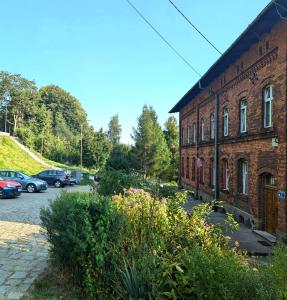 a brick building with cars parked in a parking lot at Mieszkanko in Międzylesie