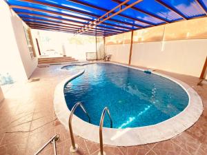 a large swimming pool in a building at Private Cottage in Sharjah