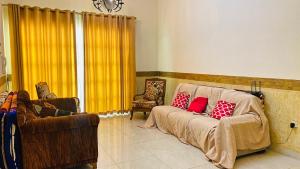 a living room with a couch with two red pillows at Private Cottage in Sharjah