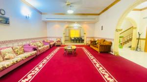 a living room with couches and a red rug at Private Cottage in Sharjah