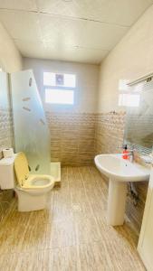 a bathroom with a toilet and a sink at Private Cottage in Sharjah