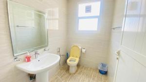 a bathroom with a yellow toilet and a sink at Private Cottage in Sharjah