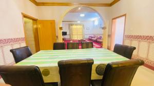 a dining room with a table and chairs and a mirror at Private Cottage in Sharjah