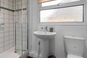 a bathroom with a sink and a toilet and a window at Maple House - Park View Sleeps 7 in Exeter +26 photos