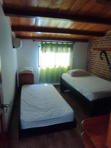 two beds in a room with a window at Casa Ciudad Jardin in Barranquilla