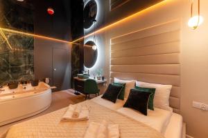 ein Schlafzimmer mit großem Bett und Badewanne in der Unterkunft Apartamenty z Jakuzzi Perłowa Przystań Rent Kołłątaja in Kołobrzeg + 76 Fotos