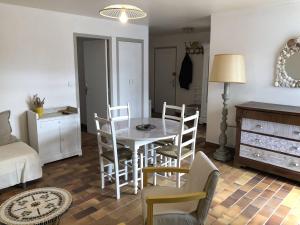 a living room with a dining room table and chairs at Appartement T3, avec terrasse, place de parking privée in Saintes-Maries-de-la-Mer