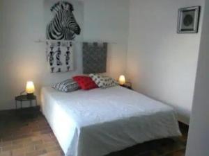 a bedroom with a bed with a zebra picture on the wall at Appartement T3, avec terrasse, place de parking privée in Saintes-Maries-de-la-Mer