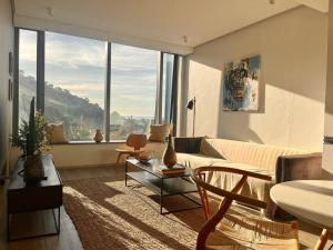 开普敦Eagles Eye, Aestetic escape with panoramic views的带沙发和大窗户的客厅