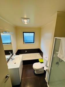 a bathroom with a toilet and a sink and a shower at Logies Lodge in Ruakaka