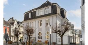 a white building with a black roof at Sleek Apartment in Troisdorf in Troisdorf