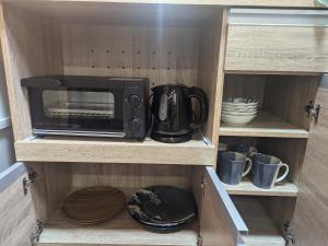 a microwave oven sitting on top of a cabinet at Matsuri House 20min to Ueno in Tokyo
