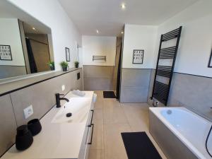 a bathroom with a tub and a sink and a bath tub at Ferienwohnung am See - Obergeschoss - Ruhige Lage - Eigener Garten in Borken