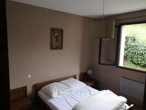 a bed in a room with a window and a bed sidx sidx sidx at Charmant gîte de montagne avec cheminée in Saint-Paul-de-Salers