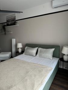 um quarto com uma cama grande e duas lâmpadas em Premium Line Apartman 3 em Sombor