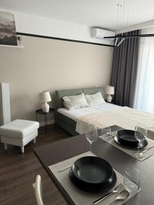 um quarto com uma cama e uma mesa com pratos e copos em Premium Line Apartman 3 em Sombor