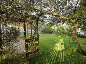 ein Pavillon in einem Garten mit einem Baum in der Unterkunft Ker EL-RAPHA in Saint-Avé