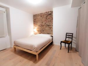 ein Schlafzimmer mit einem Bett und einem Stuhl darin in der Unterkunft Ker EL-RAPHA in Saint-Avé