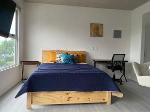 a bedroom with a bed with a blue comforter at Hermoso y Acogedor Studio Sabana, San Jose in San José +14 photos