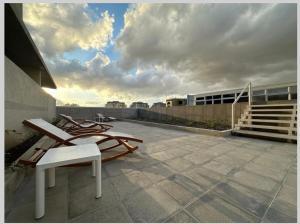 a patio with two lounge chairs on top of a building at Hermoso y Acogedor Studio Sabana, San Jose in San José