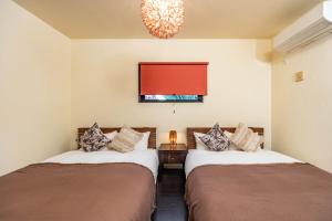 two beds in a room with a red window at 1688House美ら海 in Motobu