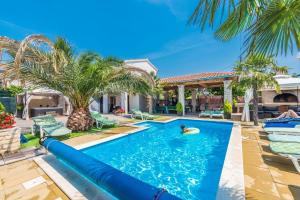 een zwembad in de achtertuin van een huis waarin iemand zwemt bij Apartments Tomo in Sukošan