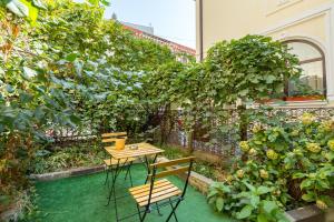 a patio with a table and chairs in a garden at Emil Balaban Luxury Apart-Hotel in Bucharest