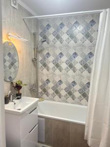 a bathroom with a tub and a sink and a shower at Квартира-студия в центре города in Balqash