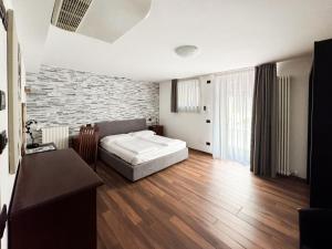 a bedroom with a bed and a brick wall at Apartments Colombara Bardolino in Bardolino +69 photos