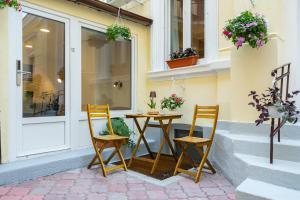 two chairs and a table in front of a building at Emil Balaban Luxury Apart-Hotel in Bucharest
